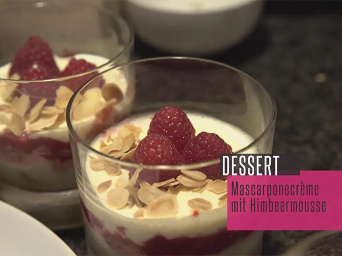 Zwei Gläser mit Himbeer-Mascarpone-Creme, garniert mit frischen Himbeeren und Mandelblättchen. Ein köstliches Dessert.