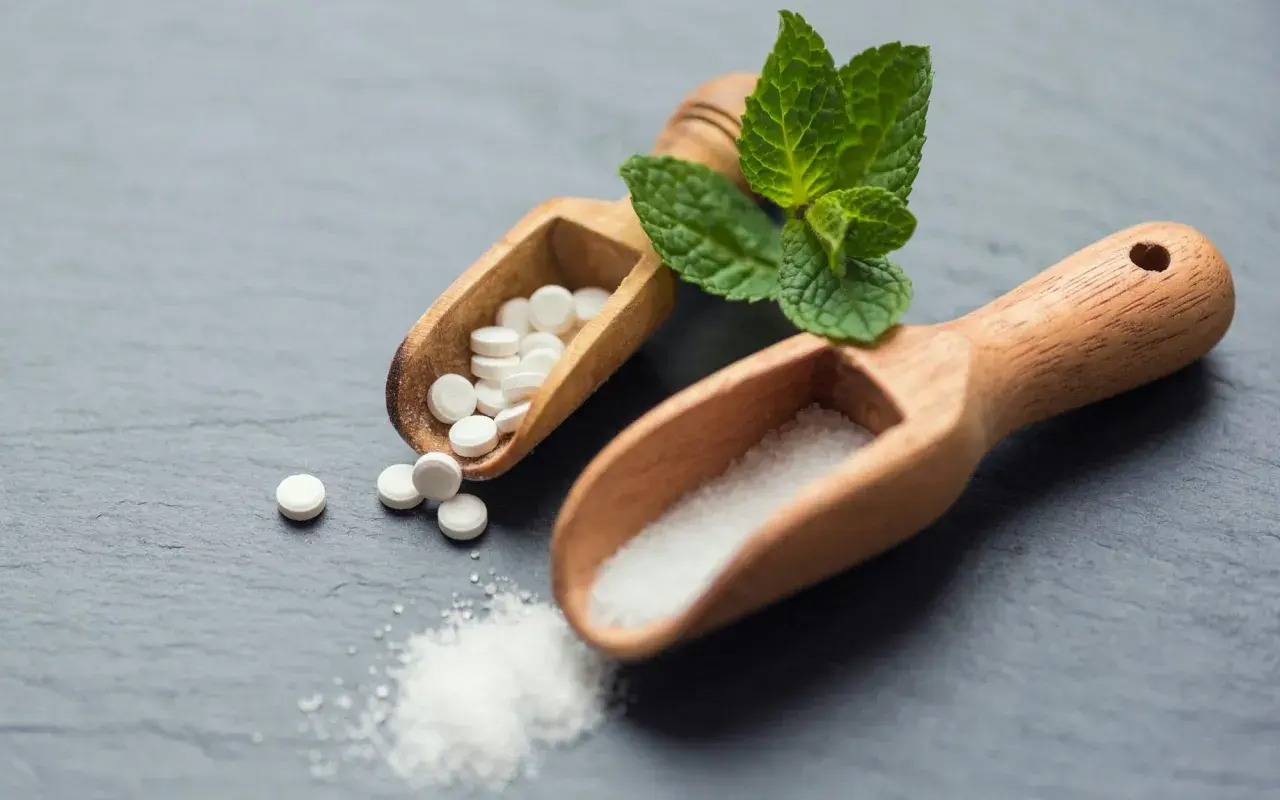 Två träskopor med socker och stevia-tabletter. Är stevia farligt? Frågan kvarstår.
