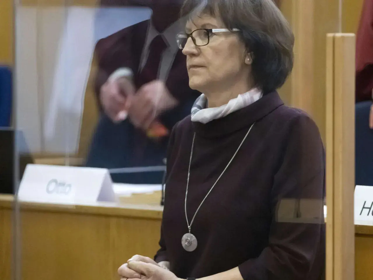 Frau mit Brille und Kette im Gerichtssaal, möglicherweise die stephan ernst ehefrau, blickt nachdenklich.