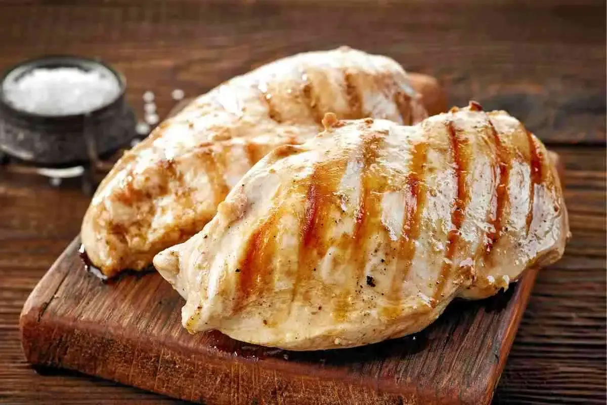 Petto di pollo alla griglia, perfetti secondi di carne da preparare in anticipo. Un contorno di sale completa l'immagine.