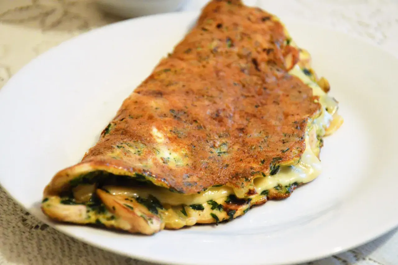 Złocisty omlet z serem i ziołami, idealny pomysł na szybką kolację.