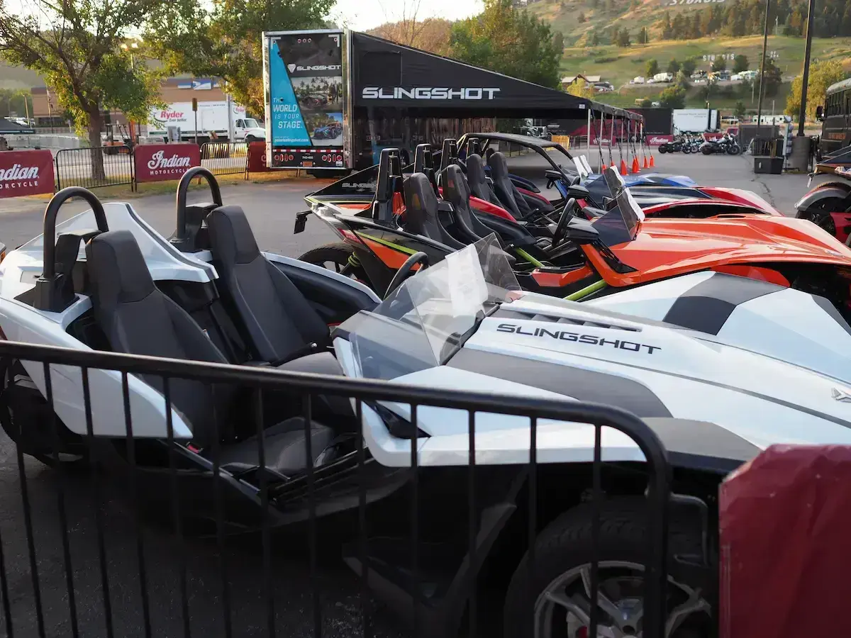 Mehrere bunte Slingshot-Autos stehen nebeneinander, bereit für eine aufregende Fahrt.
