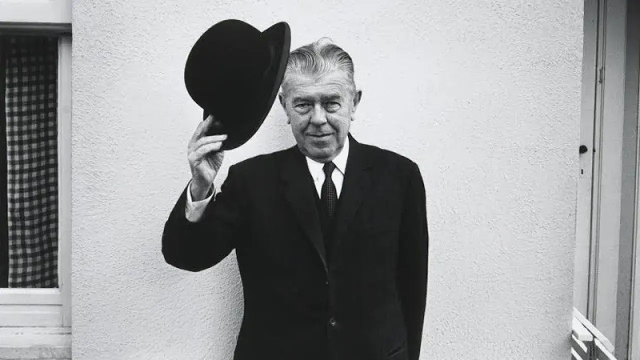 Hombre con bombín saluda, como en un espejo de Magritte.