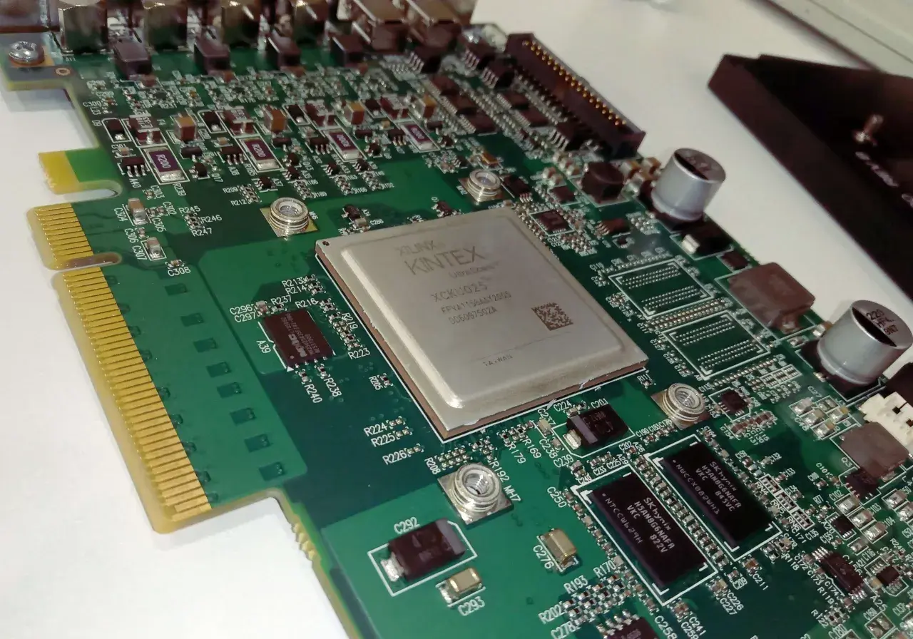 Placa de circuito impreso con un chip Xilinx Kintex FPGA. Este chip es el corazón de la placa, permitiendo la configuración de hardware para diversas aplicaciones.