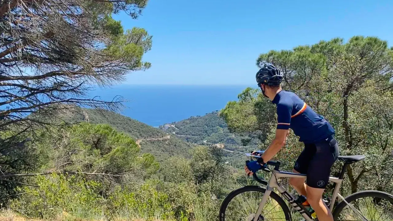 Cyclist enjoys a scenic ride, taking in breathtaking coastal views. This could be one of the best cycling routes in Europe.