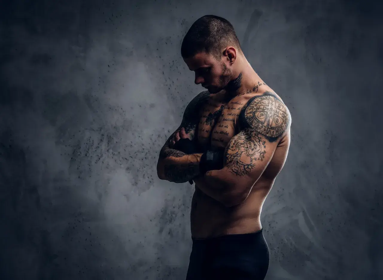 Mężczyzna z licznymi tatuażami na ciele, które tworzą jego drugą skórę po tatuazu.
