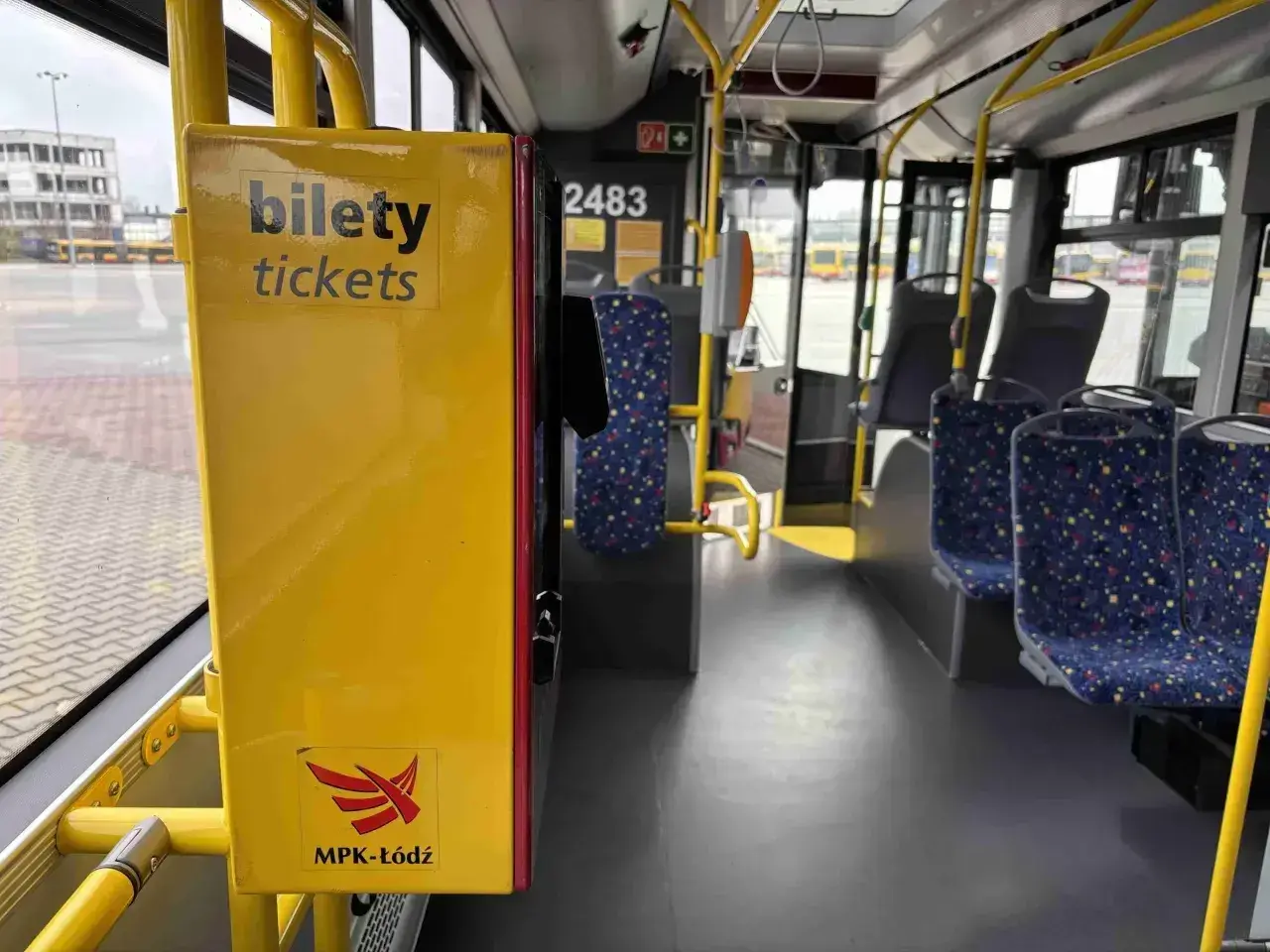 Wnętrze autobusu MPK-Łódź. Żółty automat z napisem "bilety tickets". Sprawdź cenę biletu na trasę Kutno-Łódź.