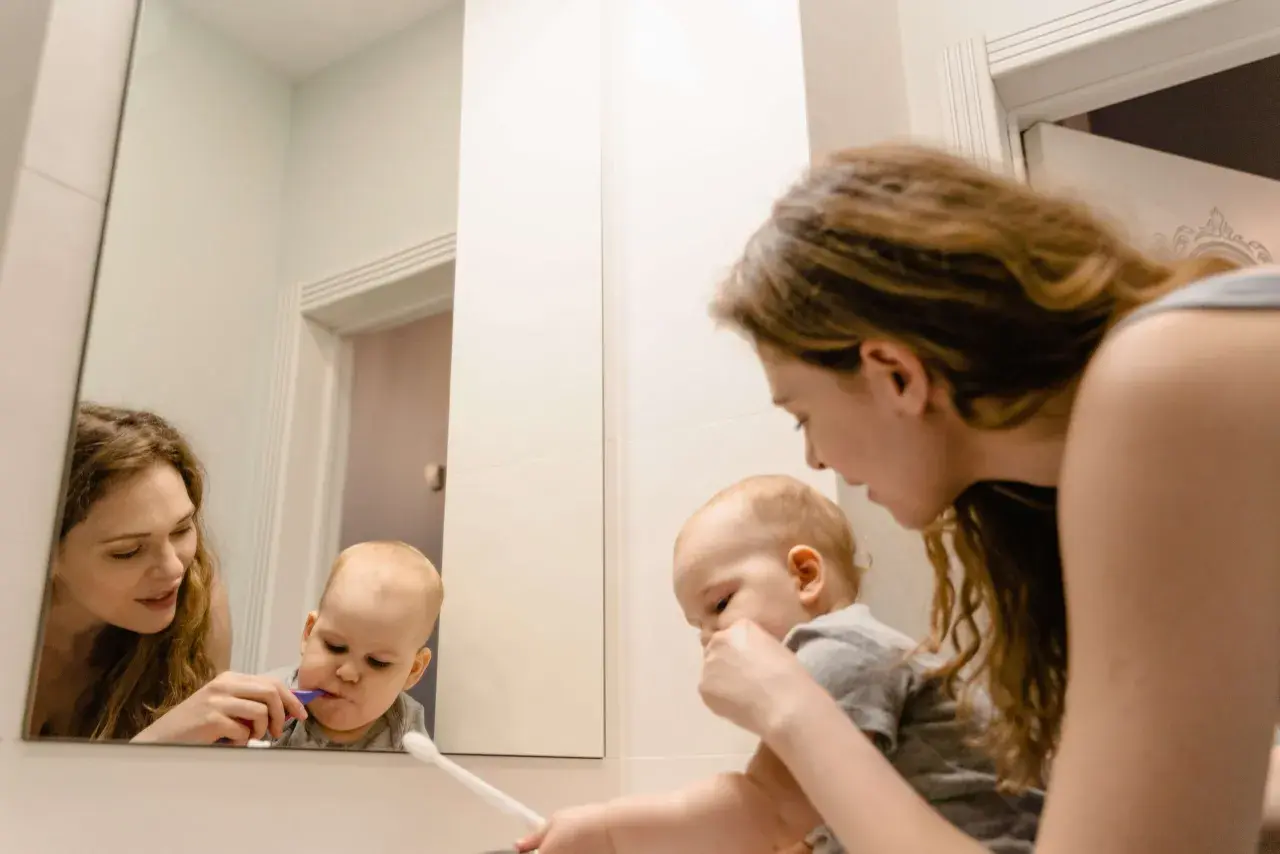 Mama pomaga dziecku myć zęby. Maluch ma lekki odruch wymiotny przy myciu zębów, ale mama go uspokaja.