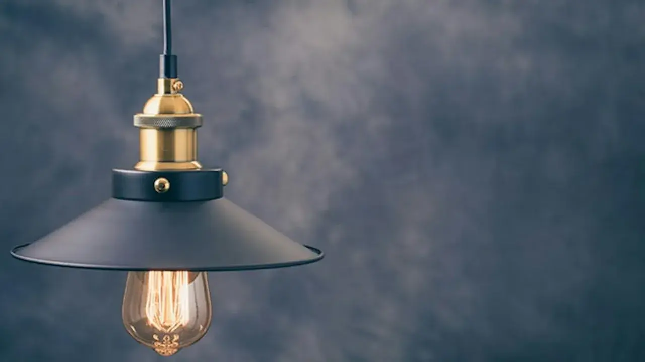 Stylowa lampa wisząca z czarnym kloszem i złotymi elementami. To modne oświetlenie idealnie wpasuje się w industrialne wnętrza.