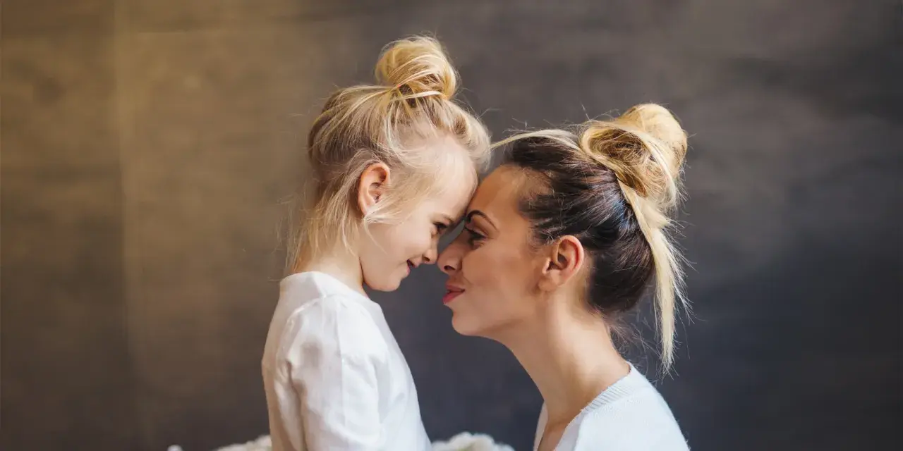 Blondynka z córką, dziecko z poprzedniego związku, czule dotykają się noskami. Nowy partner wkracza w ich życie.