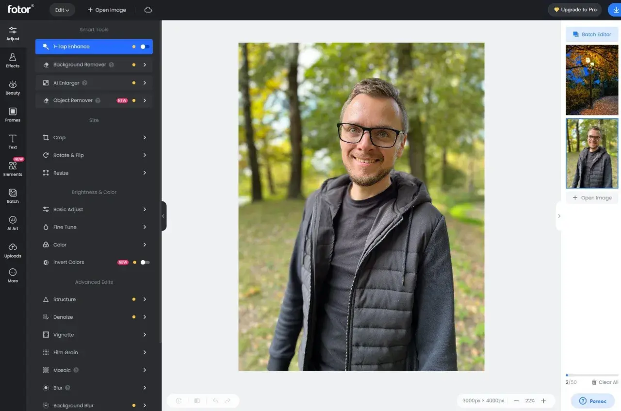 Mężczyzna w okularach uśmiecha się na tle jesiennego parku. Interfejs programu Fotor oferuje darmowy program do obróbki zdjęć po polsku.