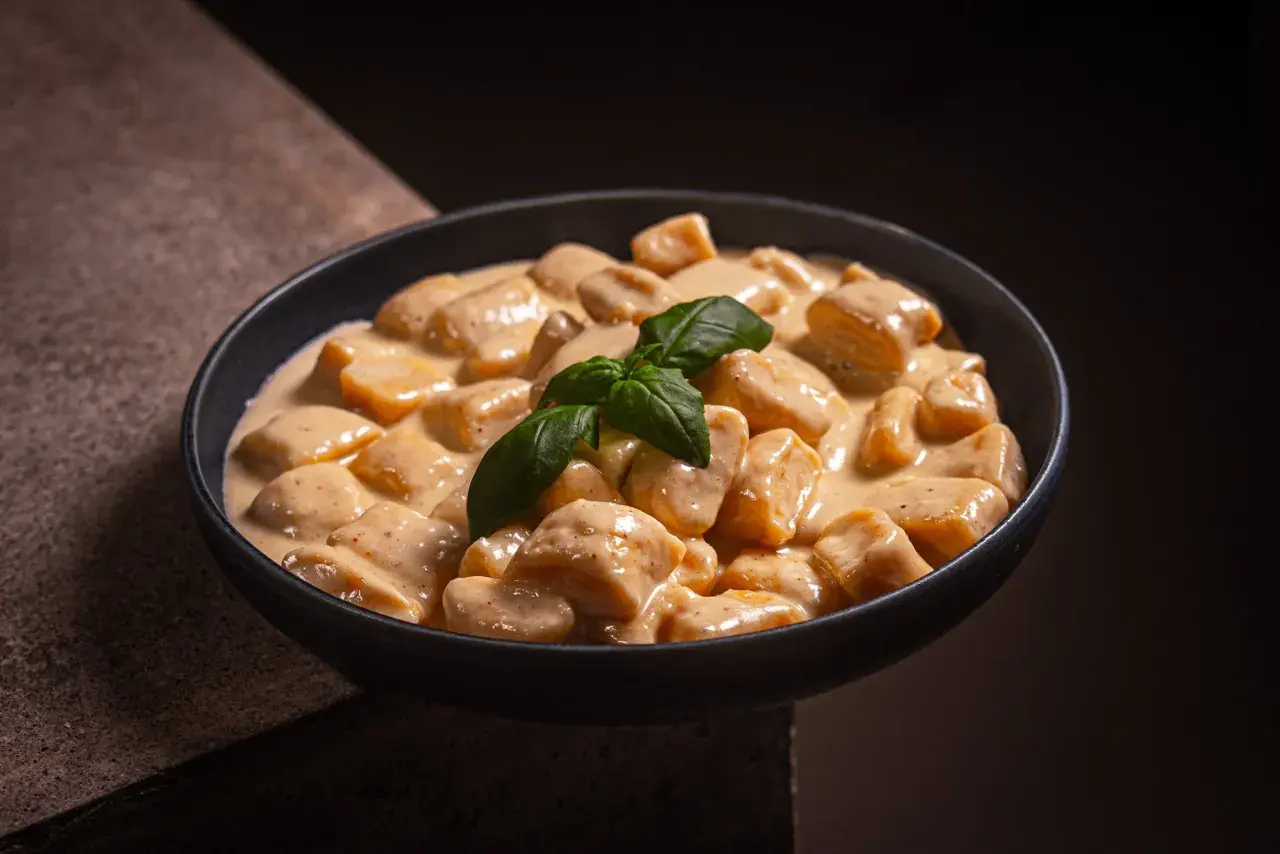 Cremige Gnocchi Gorgonzola in einer Schüssel, garniert mit frischem Basilikum. Ein Genuss für Feinschmecker.