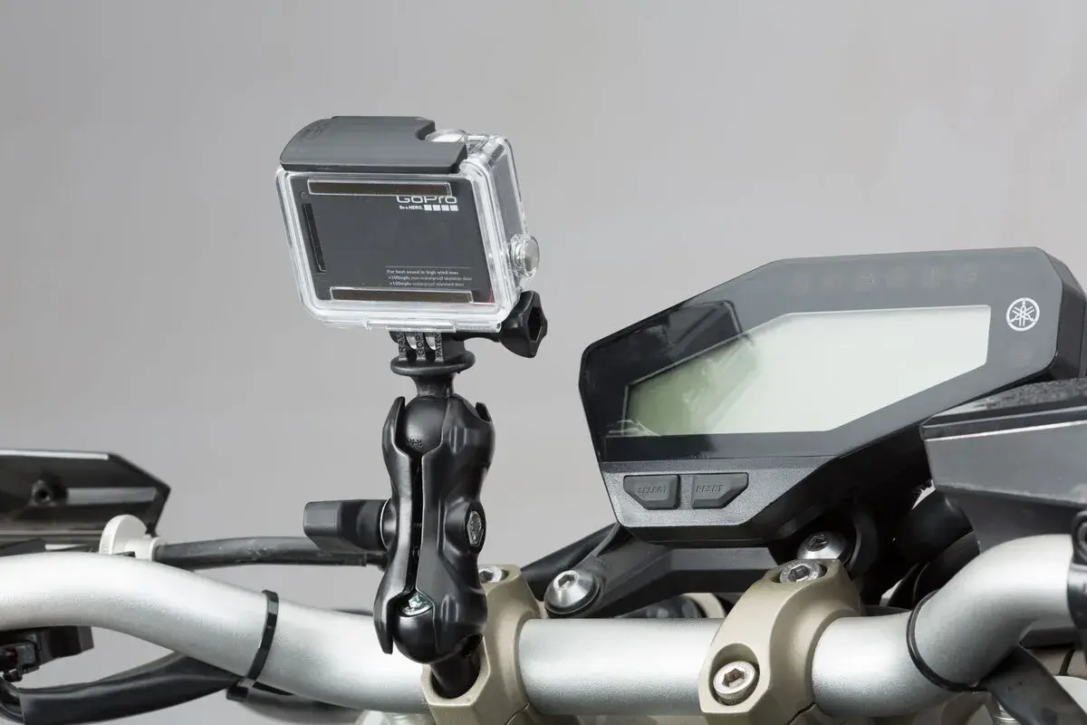 GoPro am Motorrad-Lenker montiert, bereit für actionreiche Aufnahmen. Das Display des Motorrads ist daneben zu sehen.