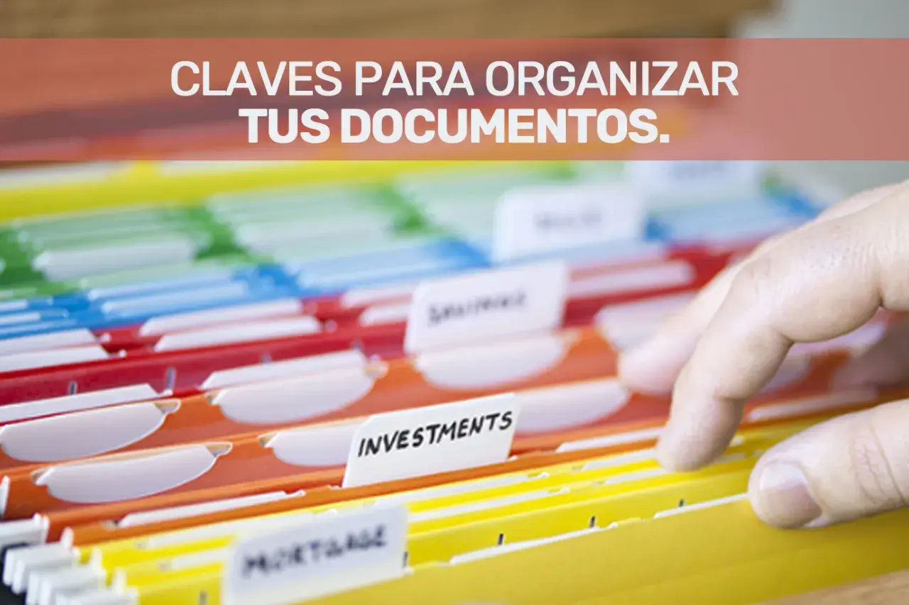 Una mano revisa carpetas de colores para la gestión documental y organización de archivos.