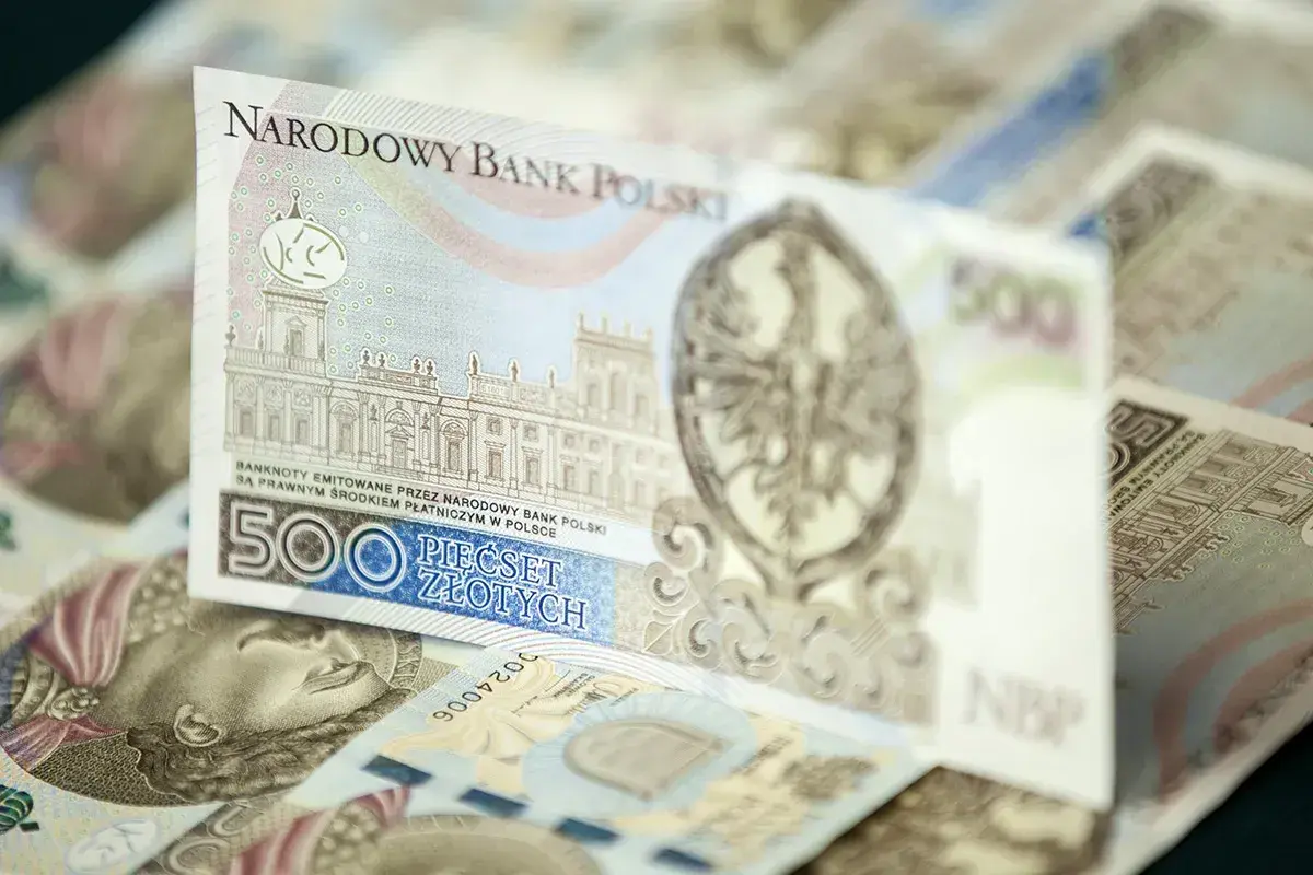 Stos banknotów 500 zł. Widoczny fragment z budynkiem i orłem.