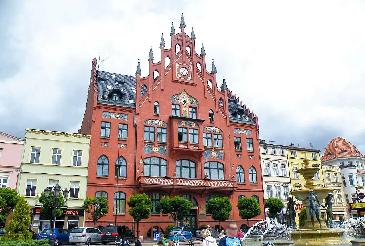 Rynek w Chojnicach z ratuszem i fontanną. Atrakcje miasta przyciągają turystów.