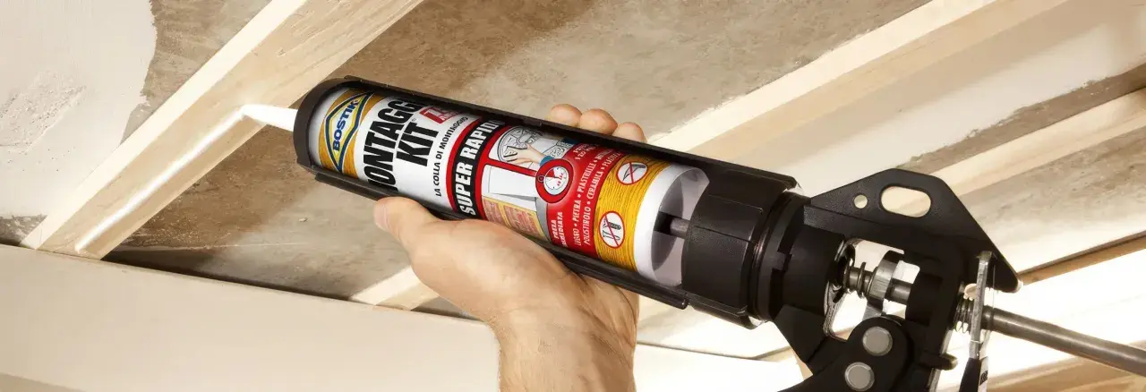 Applicazione di colla per cartongesso antiumido su listelli di legno per un montaggio rapido e sicuro.