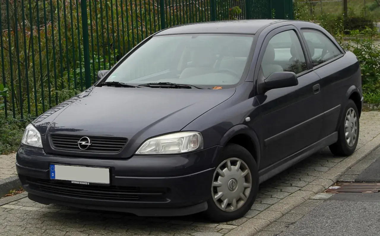 Ciemnoszary Opel Astra G 1.6 16v stoi na chodniku.