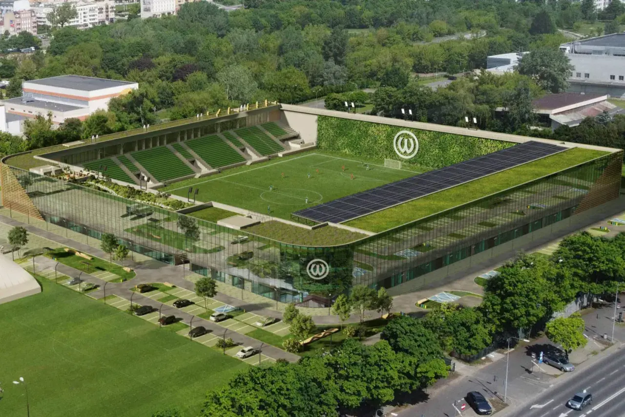 Nowoczesny stadion Warty Poznań z zielonymi dachami, panelem słonecznym i ścianą porośniętą roślinnością.