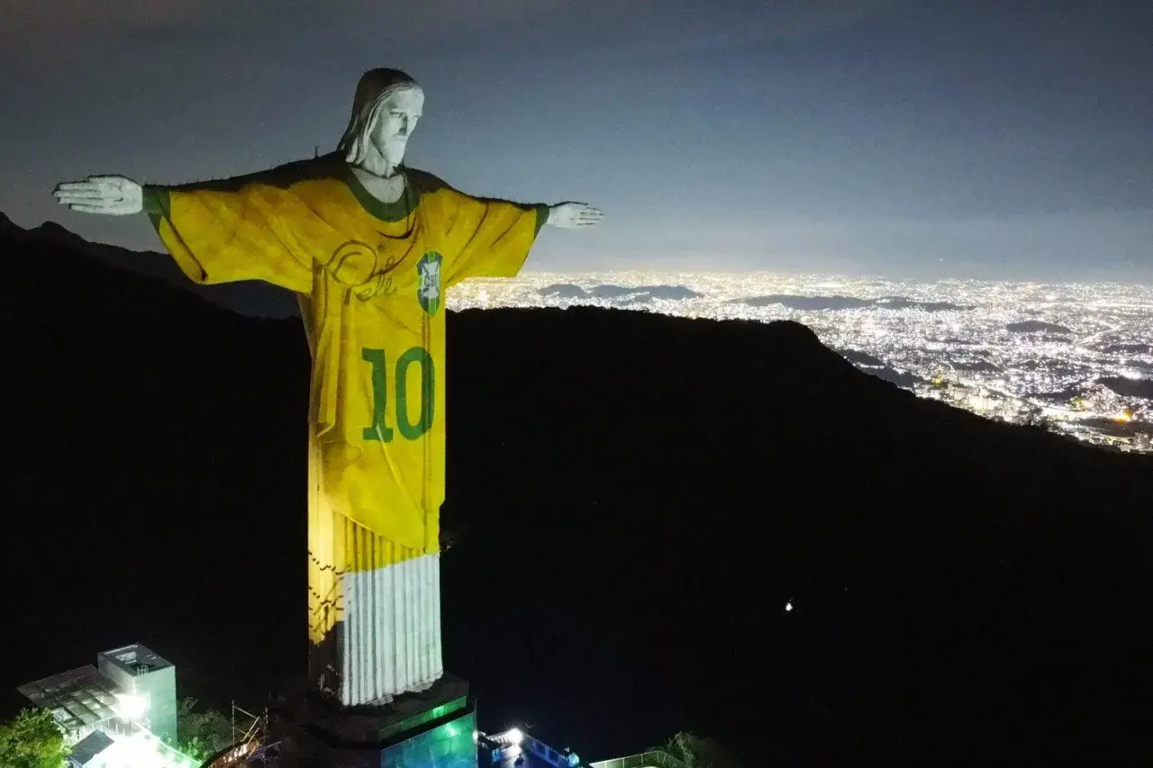 Rio de Janeiro Jezus w koszulce z numerem 10, symbolizujący dumę Brazylii, góruje nad nocnym miastem.
