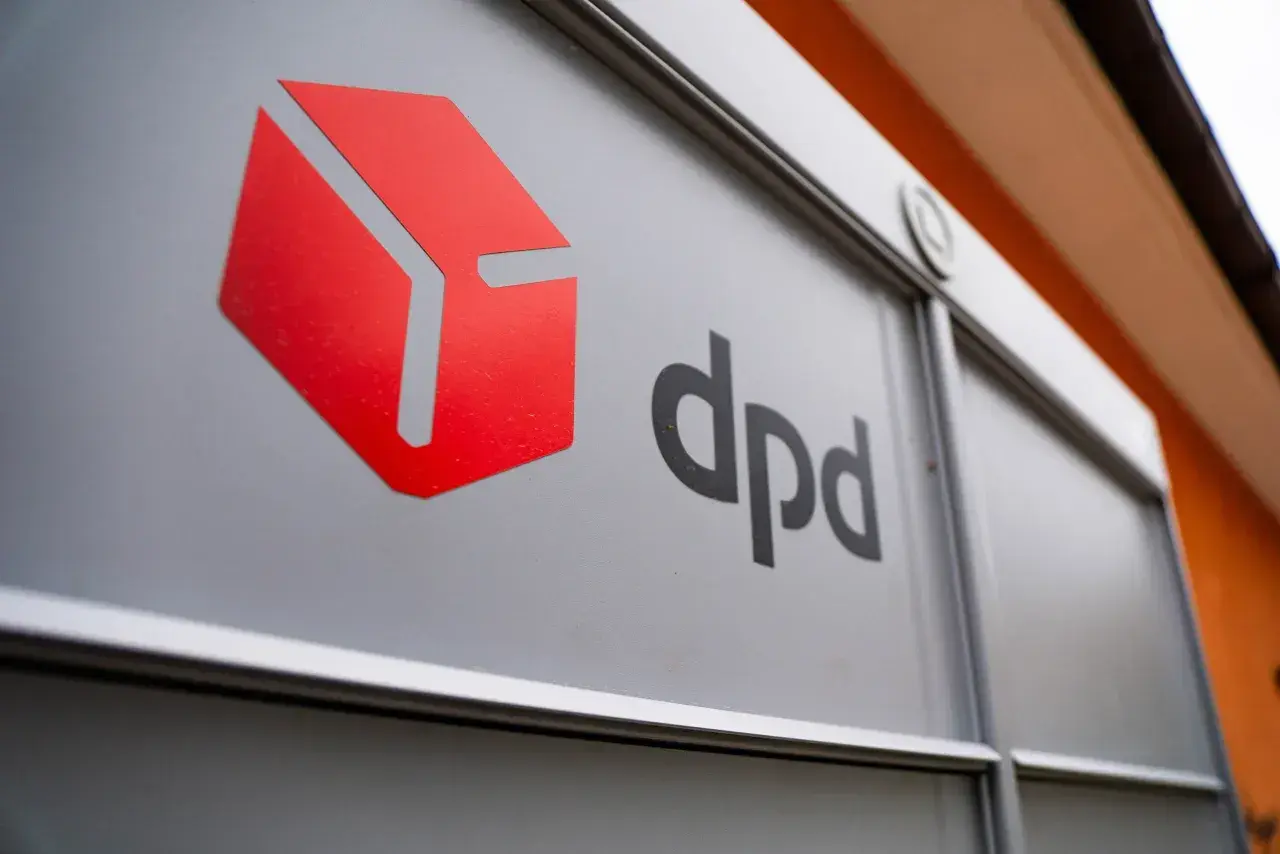 Logo DPD na szarej powierzchni. Moja paczka nadal nie dotarła, mimo że dpd kurier miał ją dostarczyć.