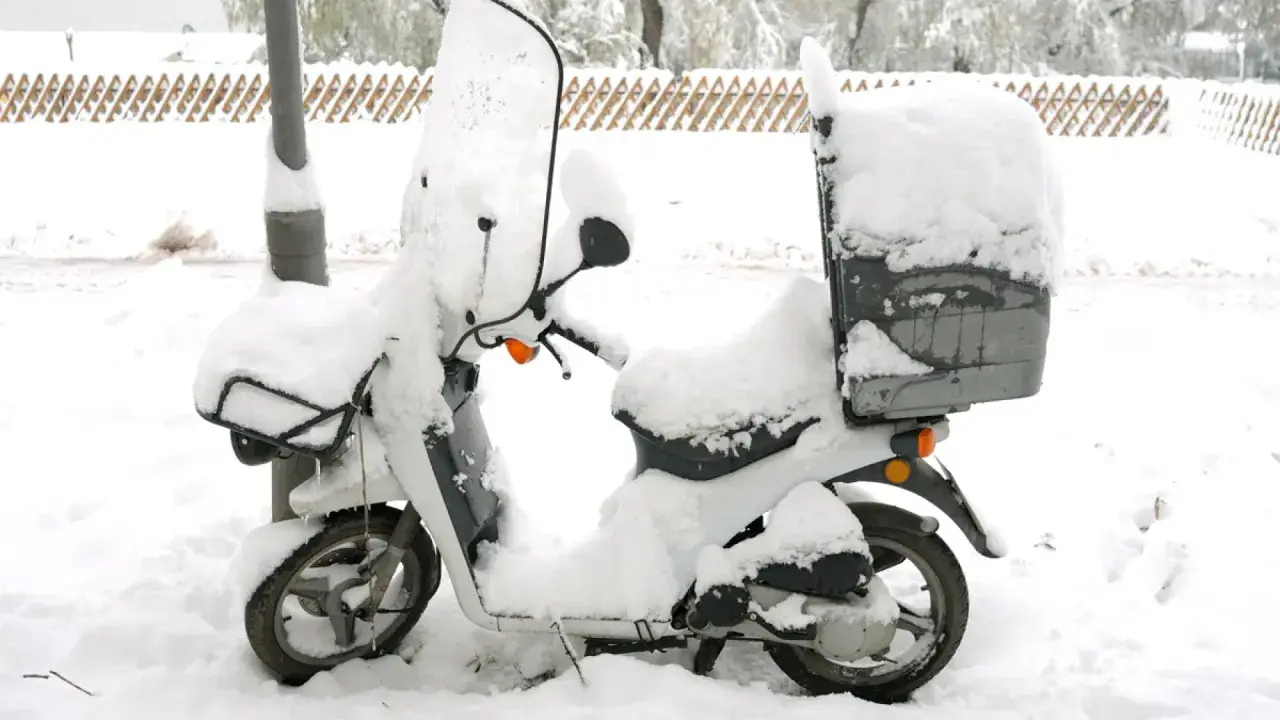Moto cubierta de nieve, lista para no arrancar en frío.