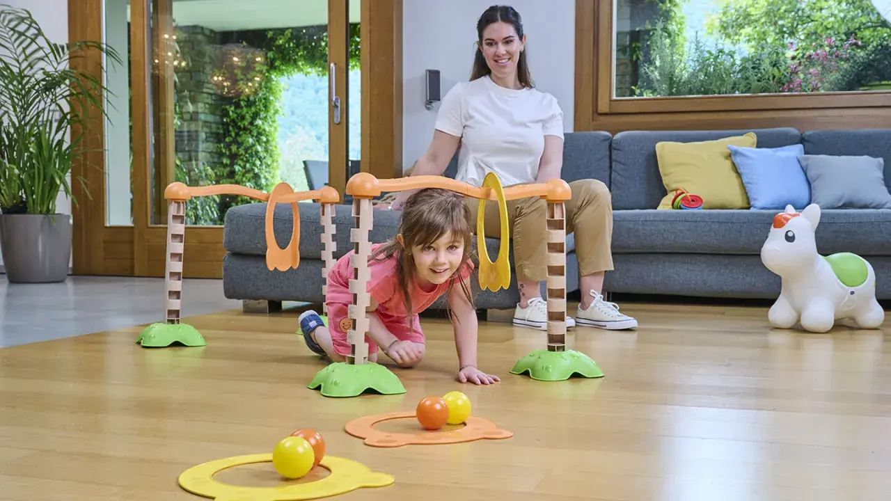 Bambina di 5 mesi esplora un percorso giochi con la mamma. Attività divertente e stimolante per lo sviluppo motorio.