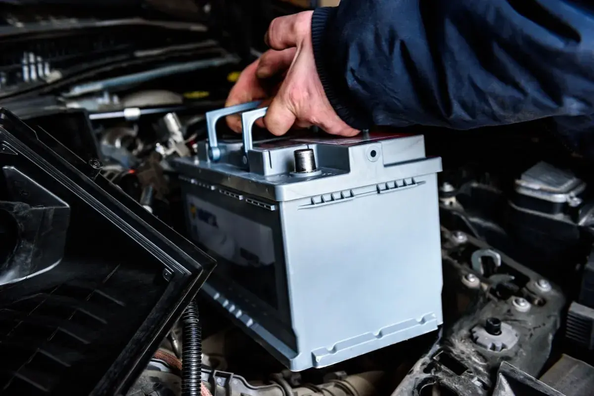 Main tenant installe une nouvelle batterie pour optimiser la durée de vie batterie start and stop de son véhicule.