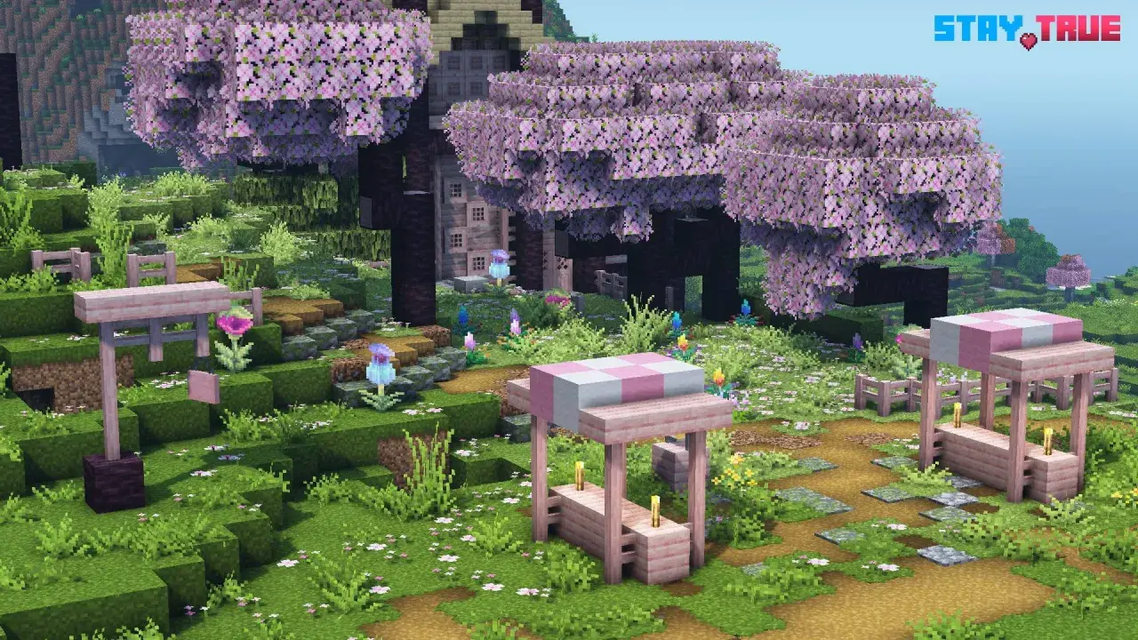 Urocza polana w grze Minecraft, gdzie drzewa kwitną na różowo, a ścieżki zdobią kamienie. Widać tu urocze stoiska i kwiaty, wszystko w stylu stay true texture pack.