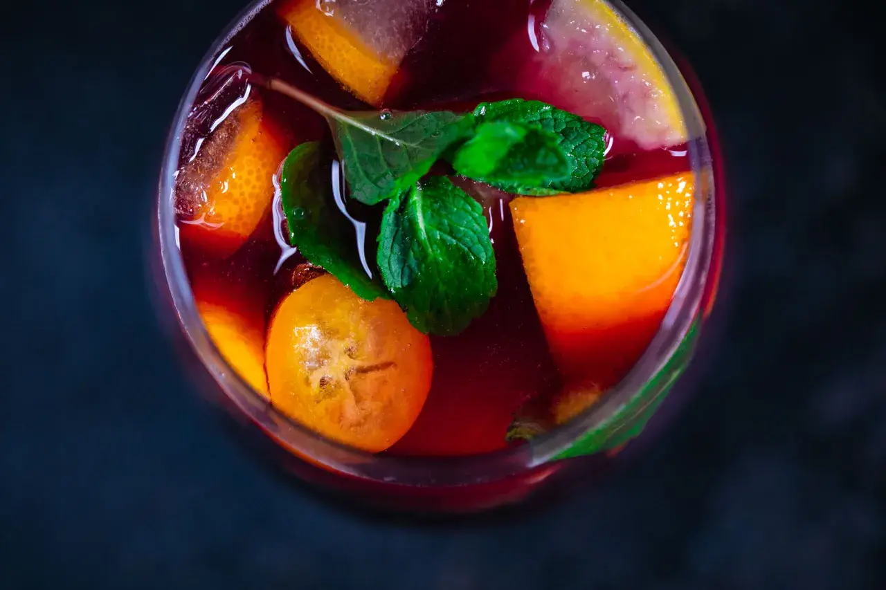 Erfrischender Sangria mit Orangen-, Zitronen- und Kumquat-Scheiben sowie Minze. Die Zutaten Sangria sind perfekt für einen heißen Sommertag.