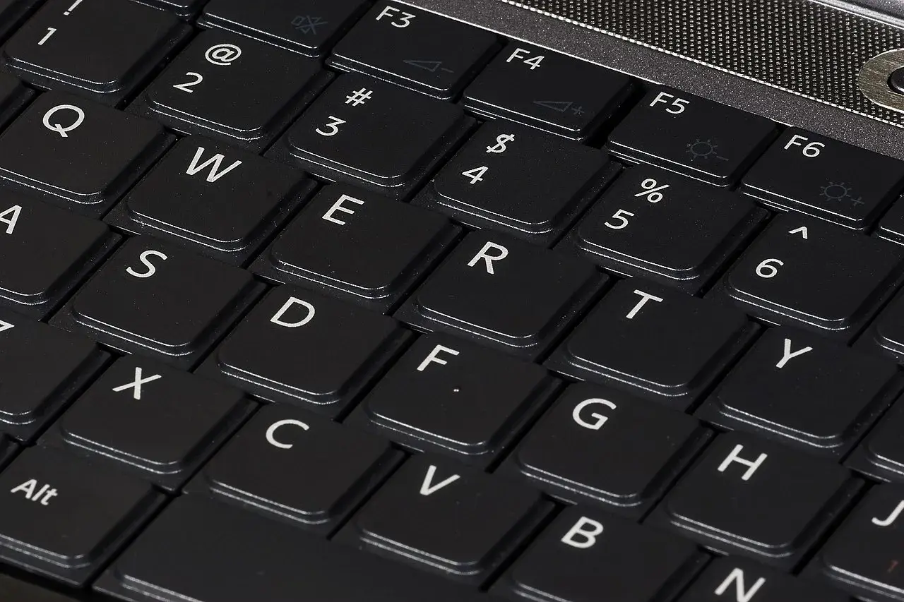 Zbliżenie na klawiaturę laptopa z widocznymi klawiszami QWERTY. Różne rodzaje klawiatur w telefonie mogą przypominać ten układ.