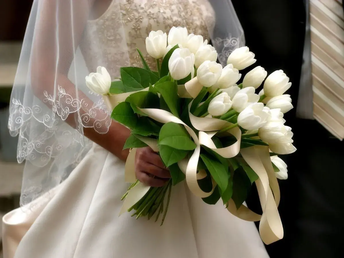 Białe tulipany w bukiecie ślubnym, idealne do połączenia z delikatnymi dodatkami.