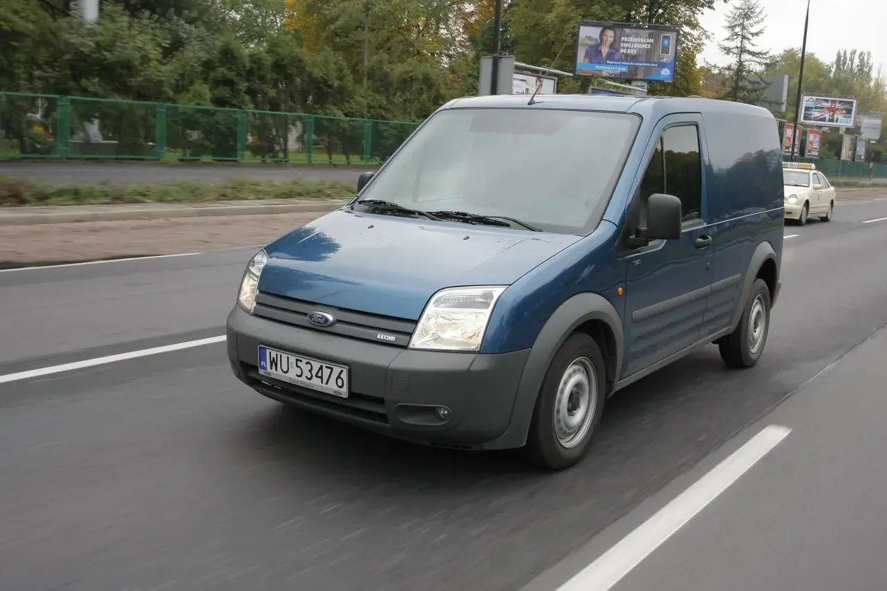 Niebieski Ford Transit 2018 na drodze, przygotowany do wymiany żarówki.