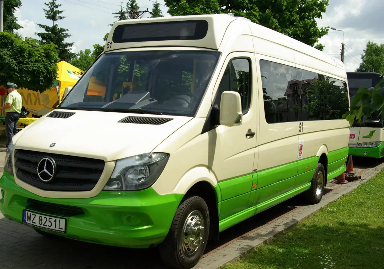 Biało-zielony bus Mercedes-Benz z numerem 51 na dachu, zaparkowany na zewnątrz.