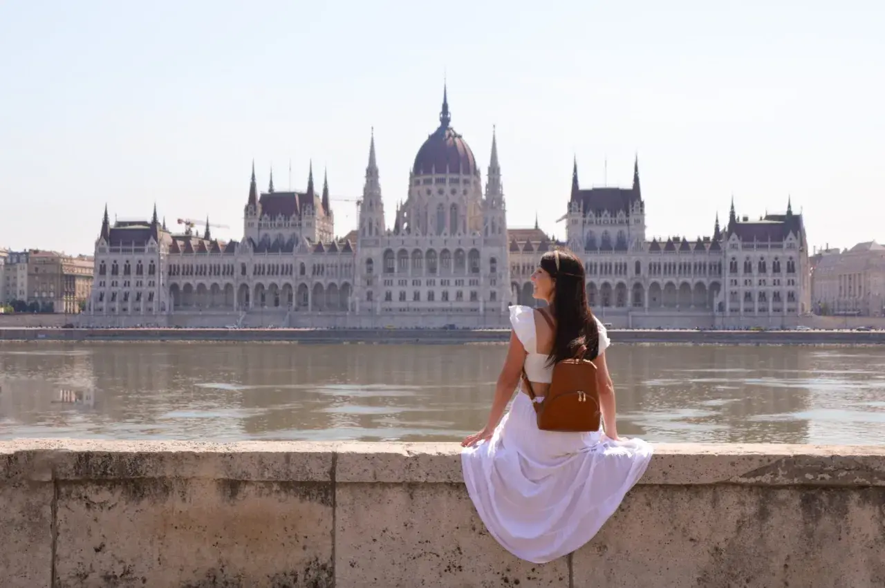 Mujer con mochila admira el Parlamento de Budapest. ¿Cuántos días para ver Budapest? ¡Un viaje inolvidable!