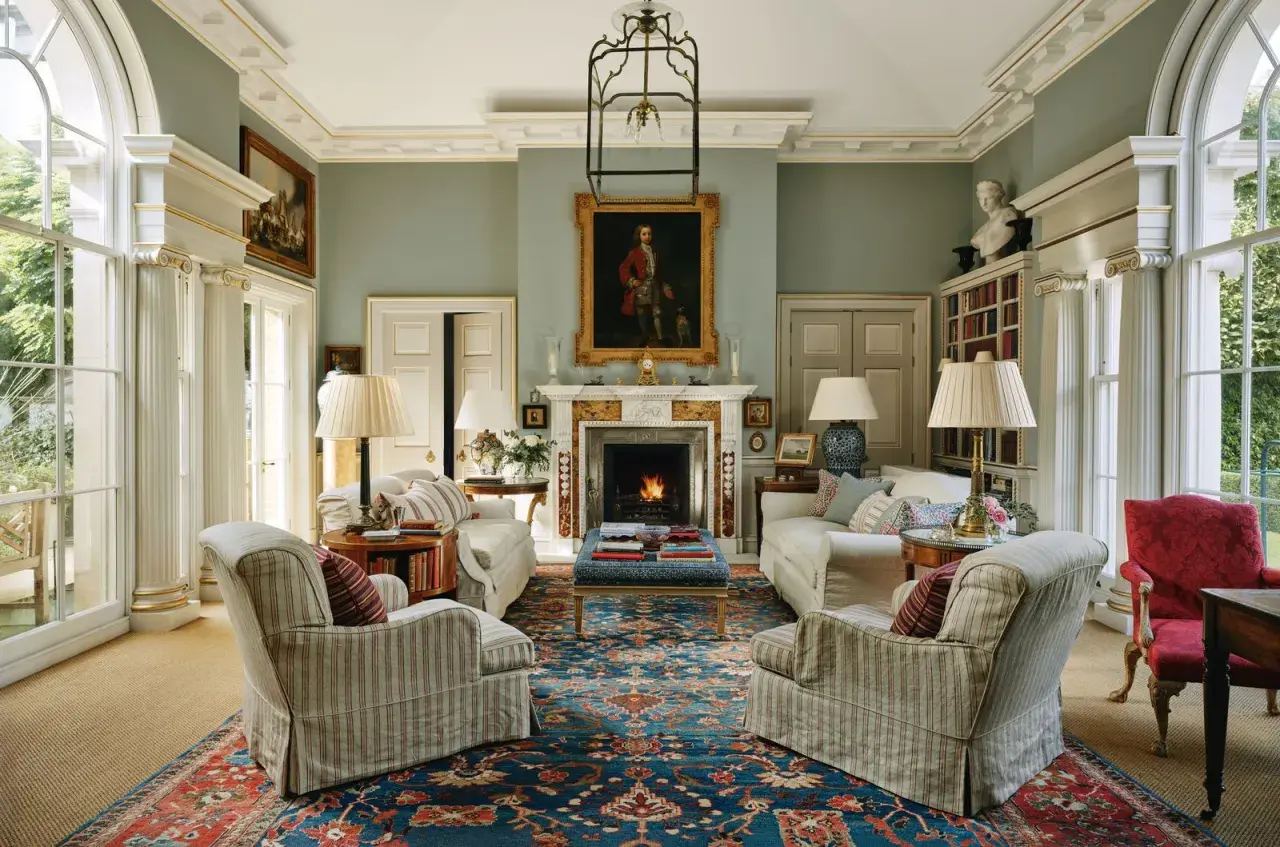 Elegant living room with fireplace, portraits, and plush seating, showcasing the expertise of home design consultants.