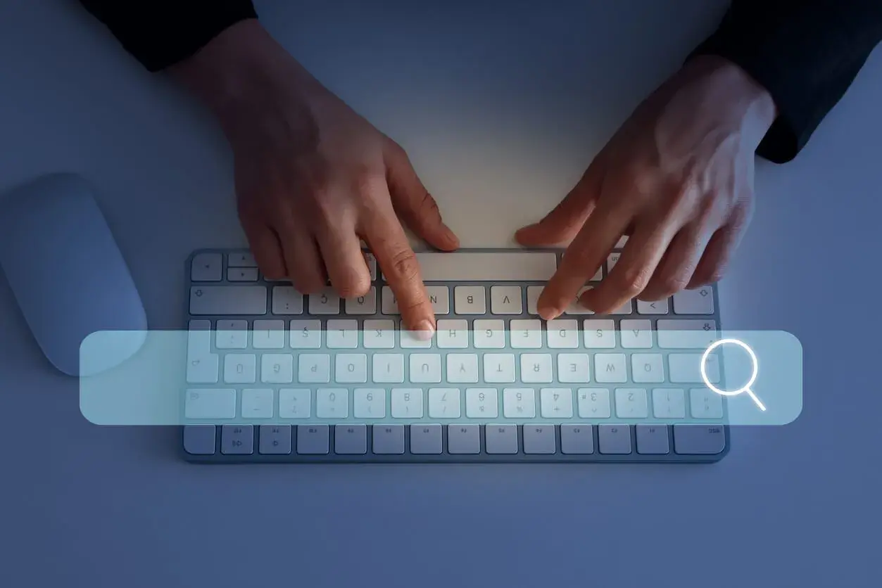 Ręce wpisują w wyszukiwarkę "jak sprawdzić swój NIP". Obok klawiatury leży myszka.
