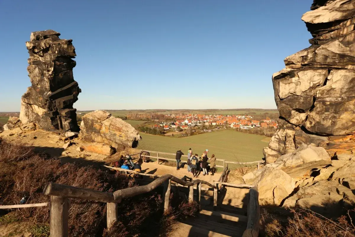 Felsformationen bei Blankenburg, ein echter Geheimtipp mit Blick auf ein malerisches Dorf. Wanderer genießen die Aussicht.