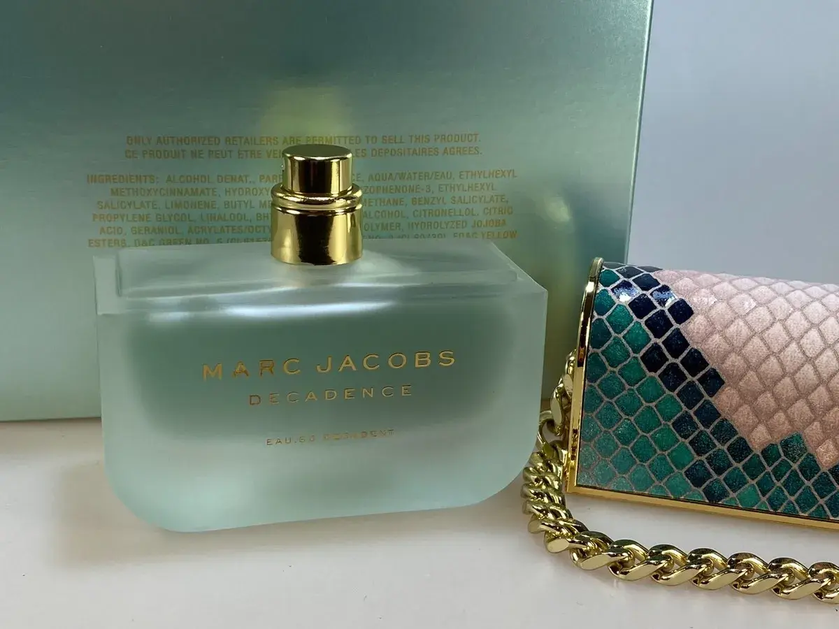Flakon perfum Marc Jacobs Decadence Eau So Decadent obok ozdobnej torebki.