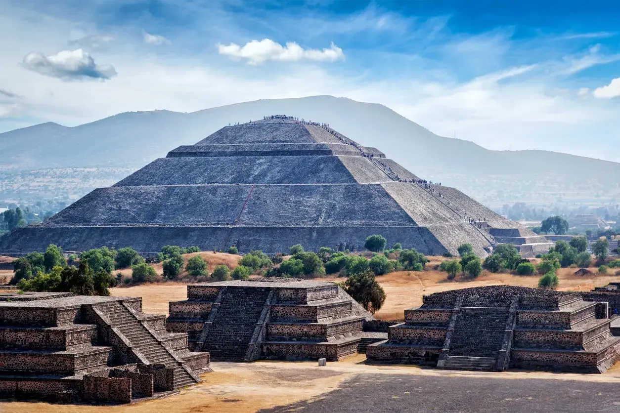 Majestätische mexikanische Pyramiden in Teotihuacán, mit Menschen, die die Stufen erklimmen.