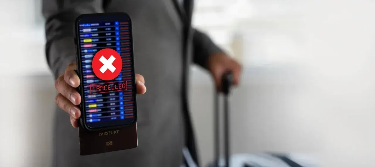 Telefon z napisem "CANCELLED" i czerwonym krzyżykiem, pod nim paszport. Podróż z Ryanair zwrot biletu stał się niemożliwy.