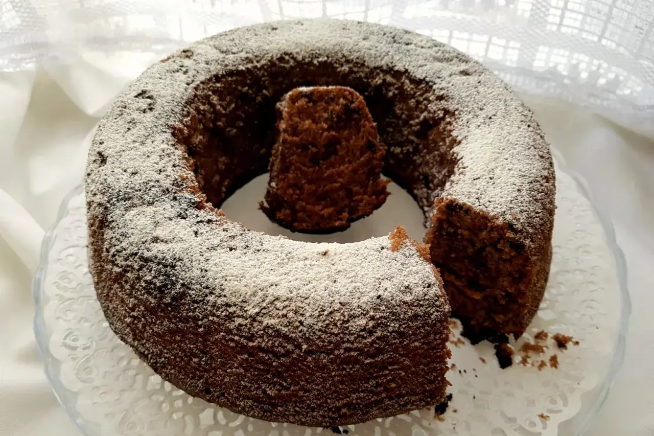 Un delizioso ciambellone al cioccolato, cosparso di zucchero a velo, pronto per essere gustato.