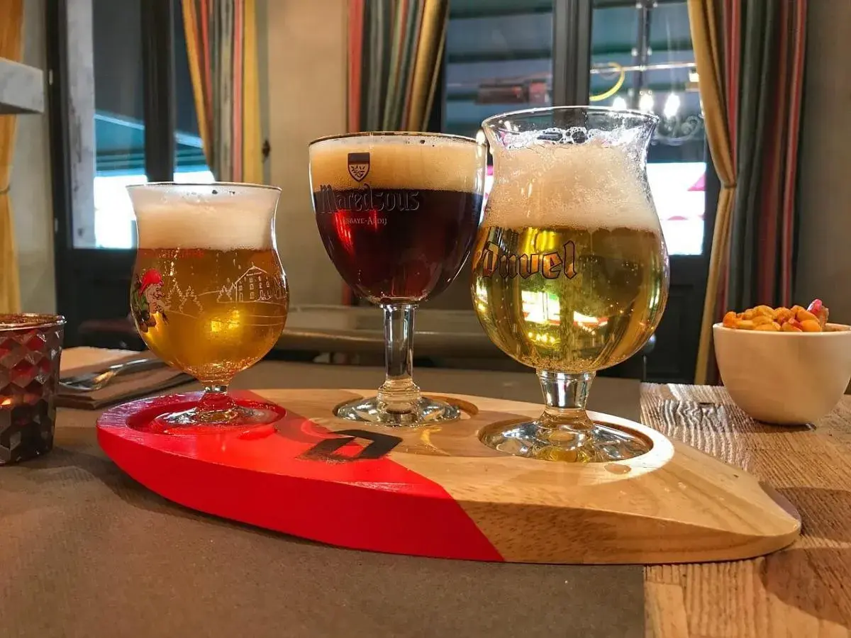 Tre bicchieri di birra su un vassoio di legno, pronti per essere gustati al tavolo.