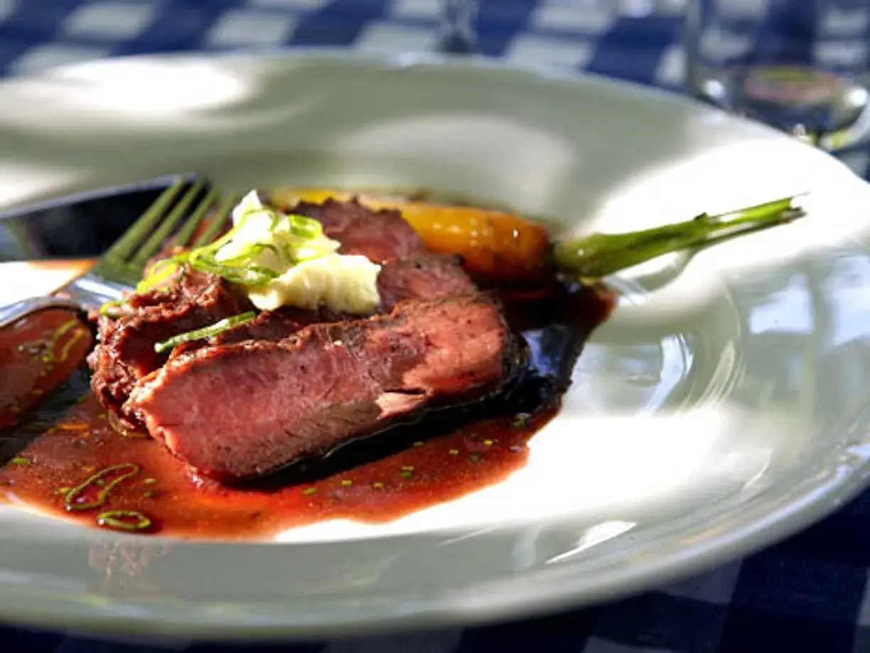 Skivat flat iron steak recept med potatismos och en grön kvist.