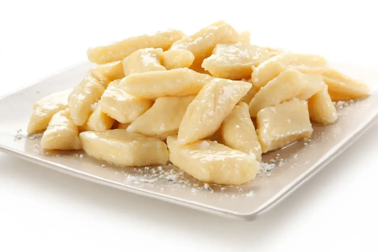 Pyszne leniwe pierogi na talerzu. Idealne co na obiad dla dzieci, posypane cukrem pudrem.