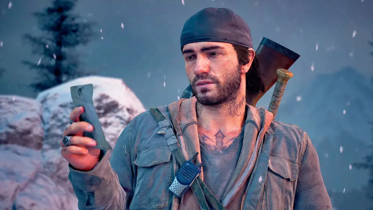 Deacon z Days Gone 2 PS4, w czapce i z siekierą za plecami, trzyma w dłoni znaleziony przedmiot.