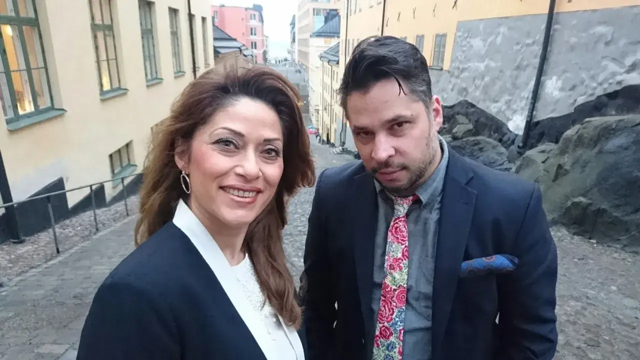Azita Shariati och en man på en kullerstensgata i Stockholm.