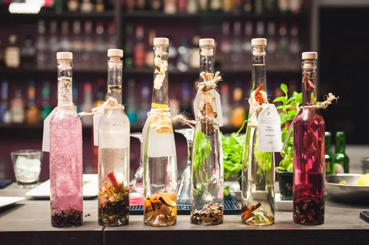 Sześć butelek z nalewkami, jedna z różową zawartością, druga z przyprawami. Zastanawiasz się, ile procent ma tequila?