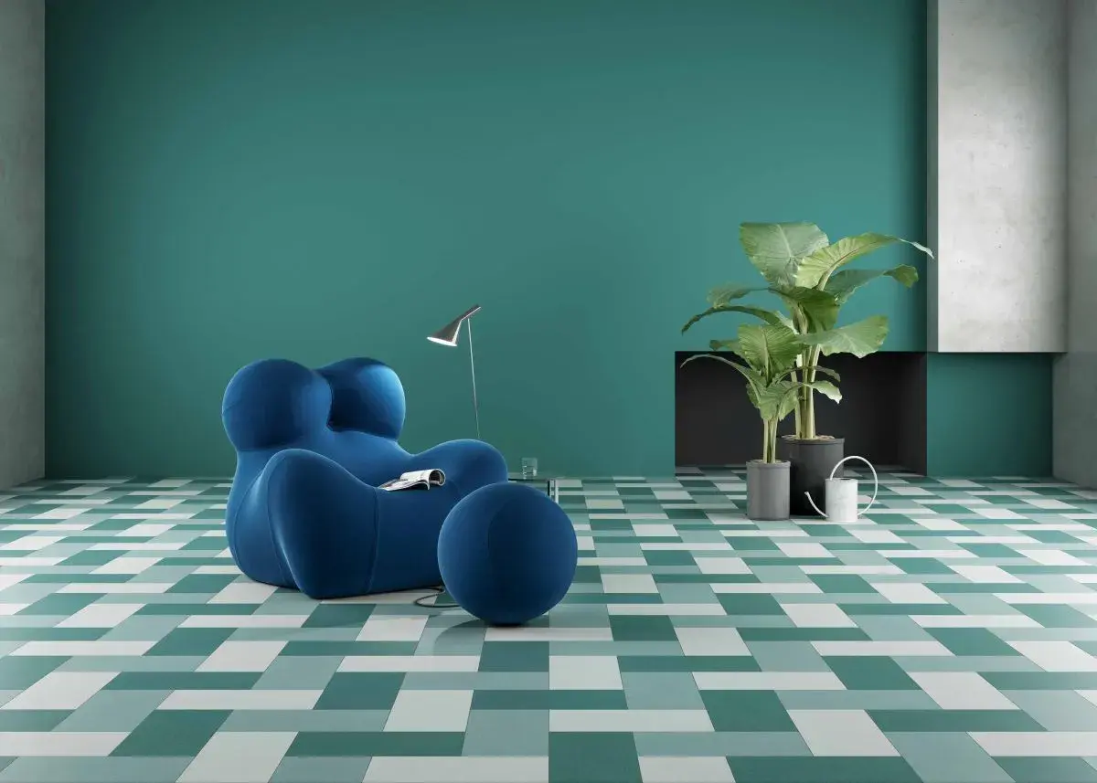 Un soggiorno moderno con poltrona blu e piante verdi, su pavimenti ecosostenibili a fantasia geometrica.