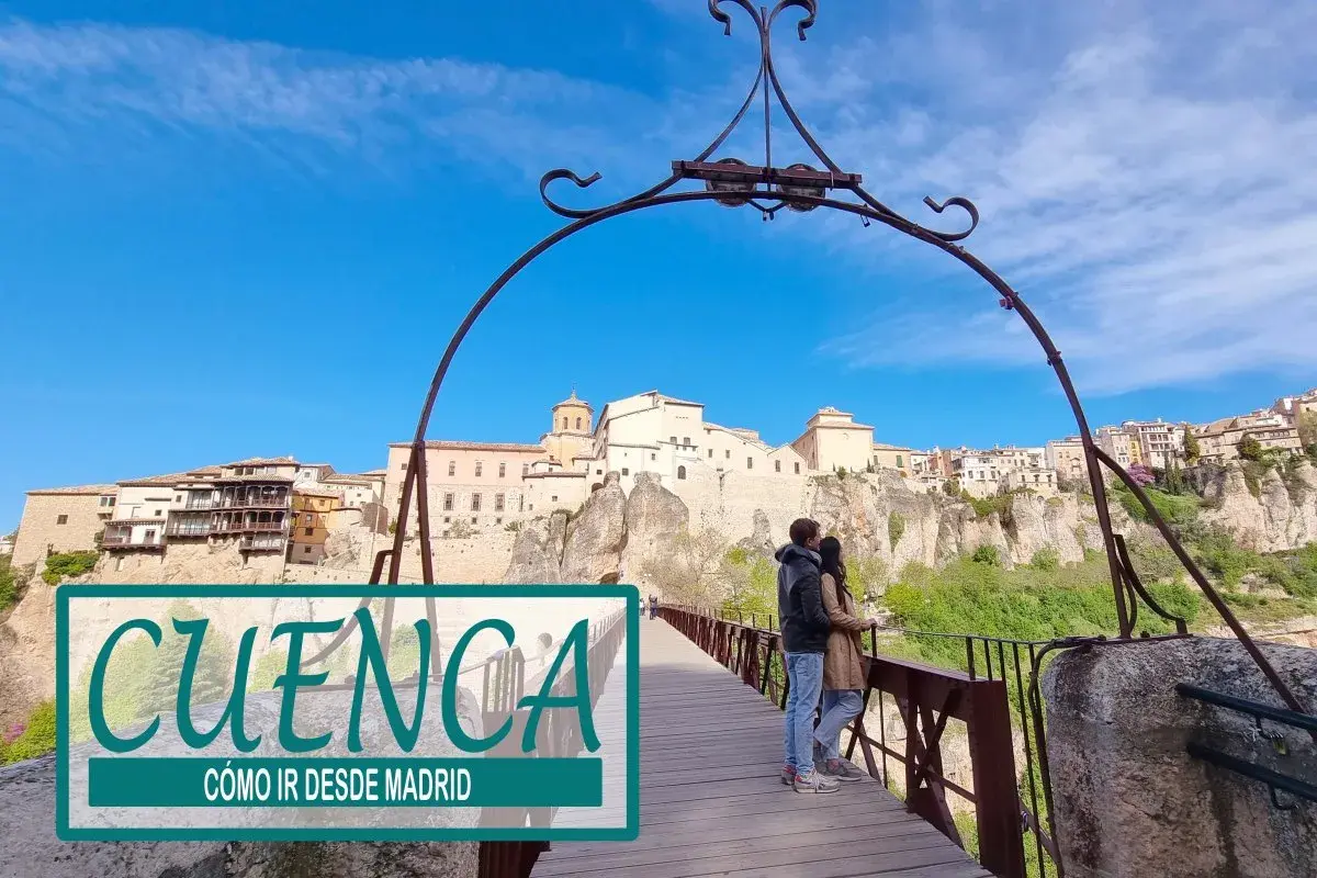 Pareja en puente de madera con vistas a la ciudad de Cuenca, un destino ideal para una escapada desde Madrid.
